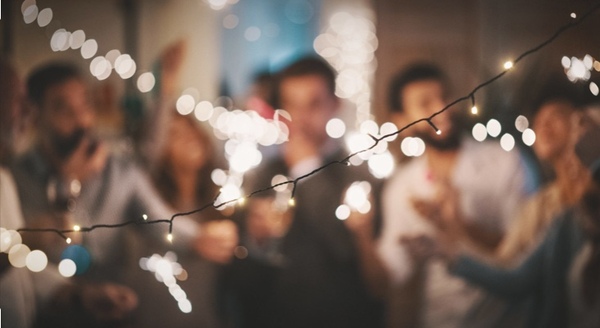 Dangling twinkle lights with a party in the background